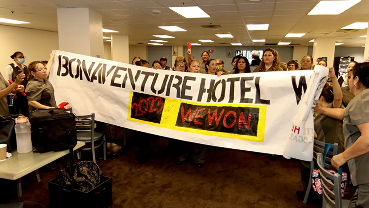 Union workers at The Westin Bonaventure Hotel & Suites hold up a banner declaring "we won."