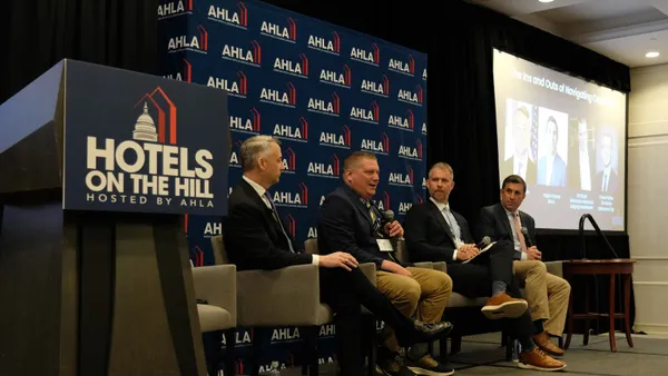 Four men speak during a panel