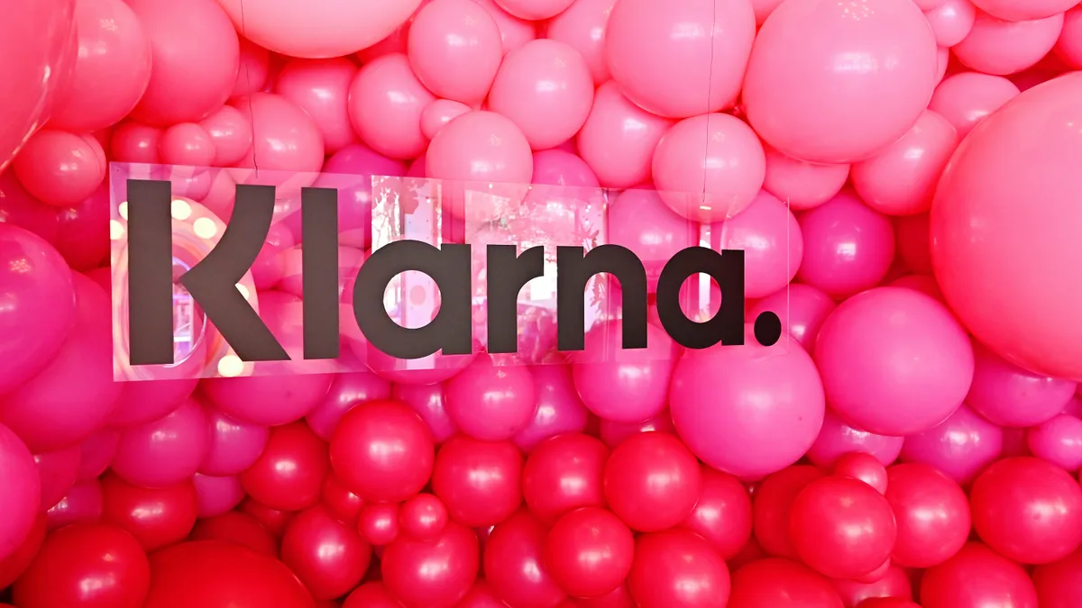 The Klarna logo in front of pink balloons