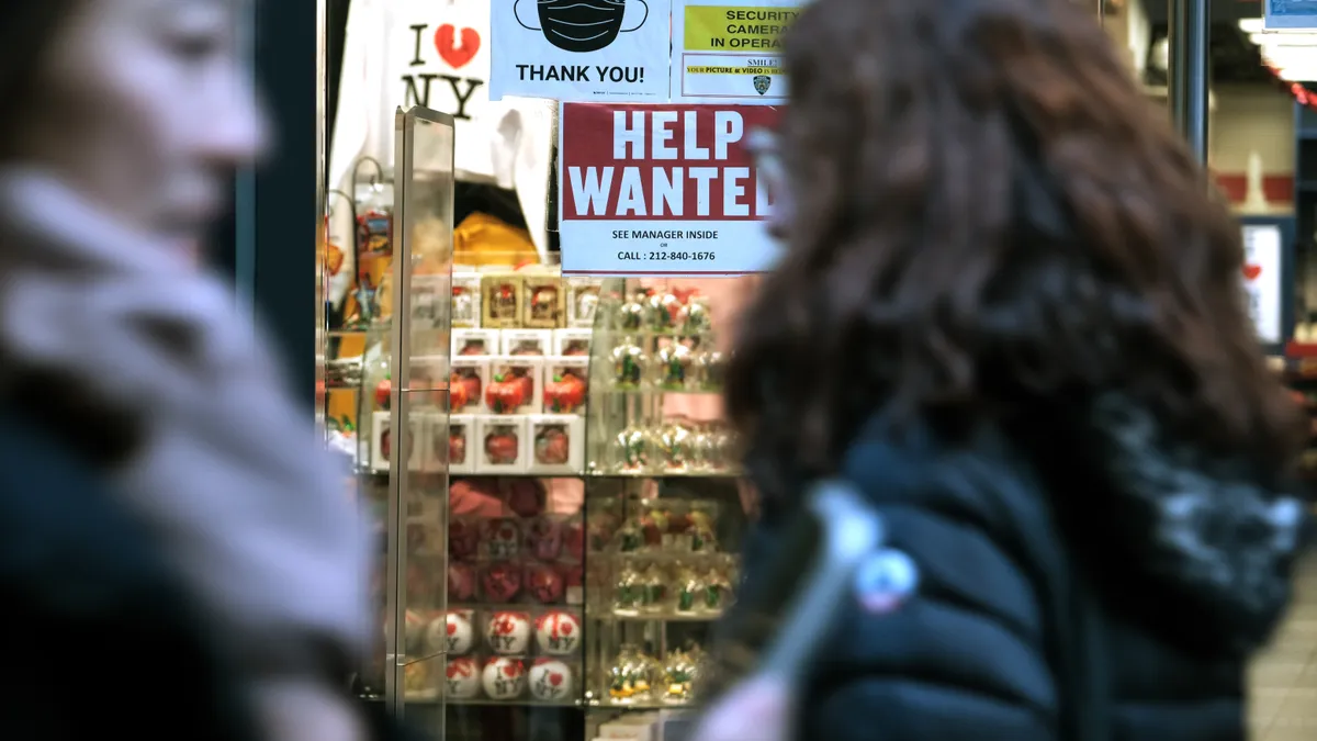 A 'help wanted' sign is displayed in a window of a store in Manhattan.