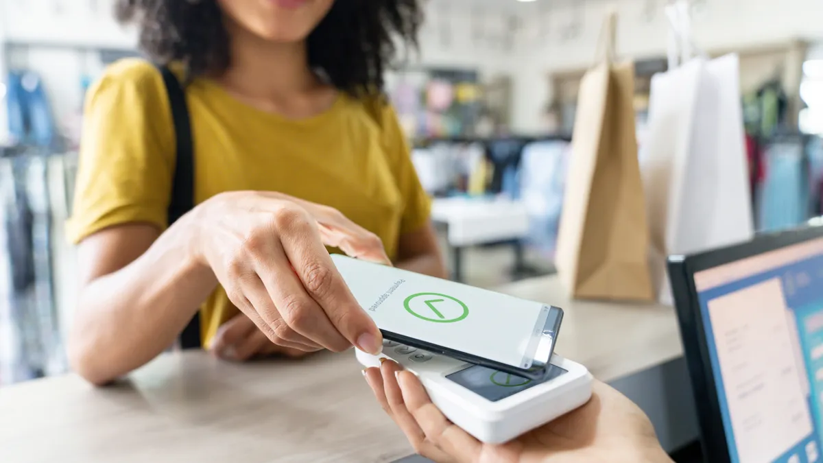 Woman making a mobile payment at a clothing store