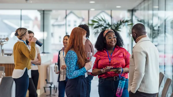 A wide angle view of a group of mixed age professionals who are taking advantage of a networking opportunity at a business conference.