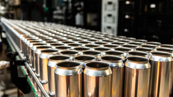 Rows of metal cans on a manufacturing line.