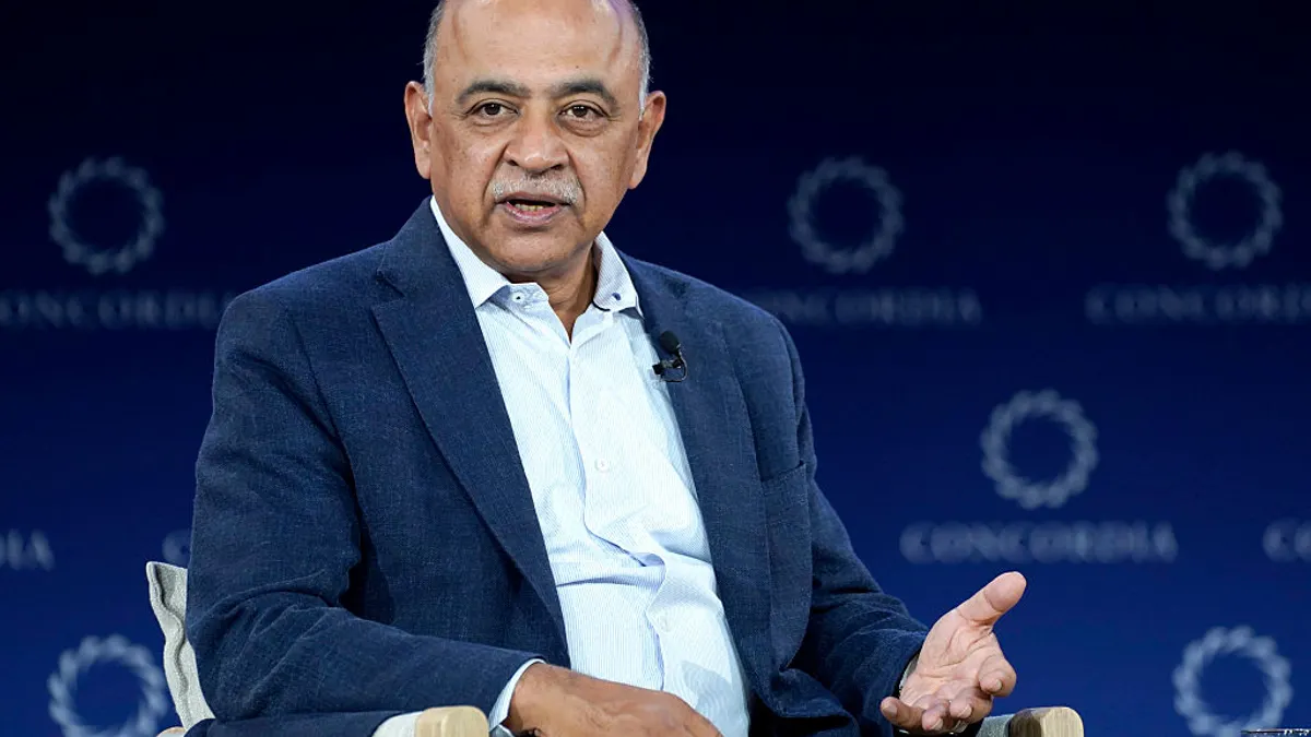 a close up shot of Arvind Krishna in business attire, speaking in a conference setting