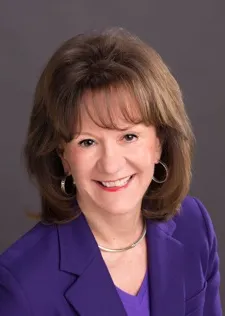 Headshot of a woman in a blue shirt.