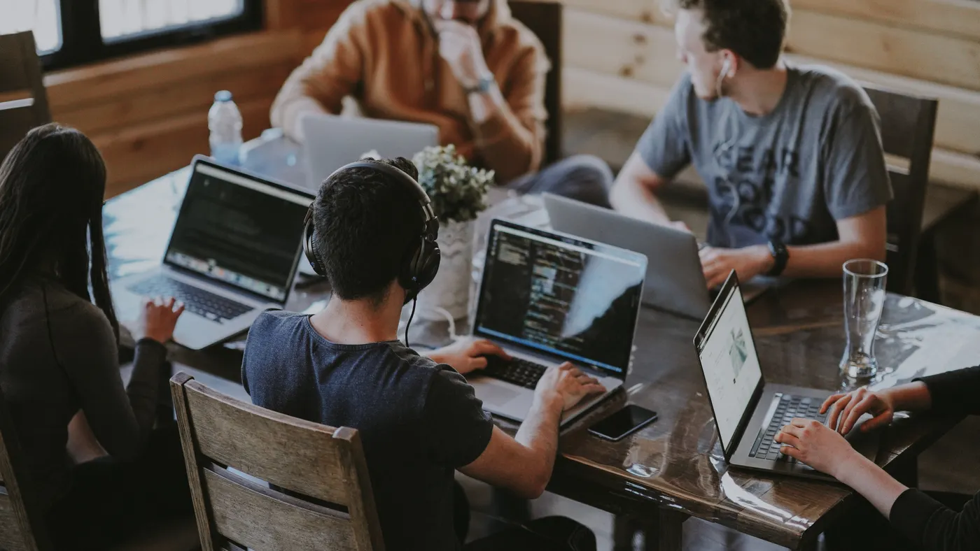 Four college students working on their laptops at a desk