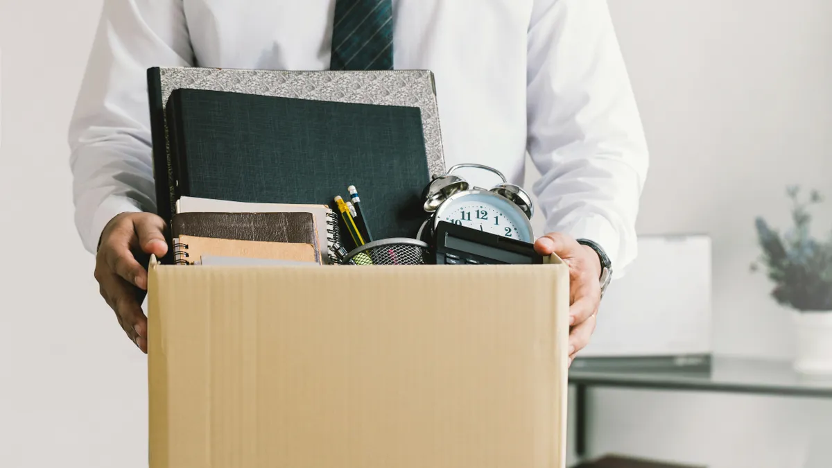 Person carries their belongings out of an office