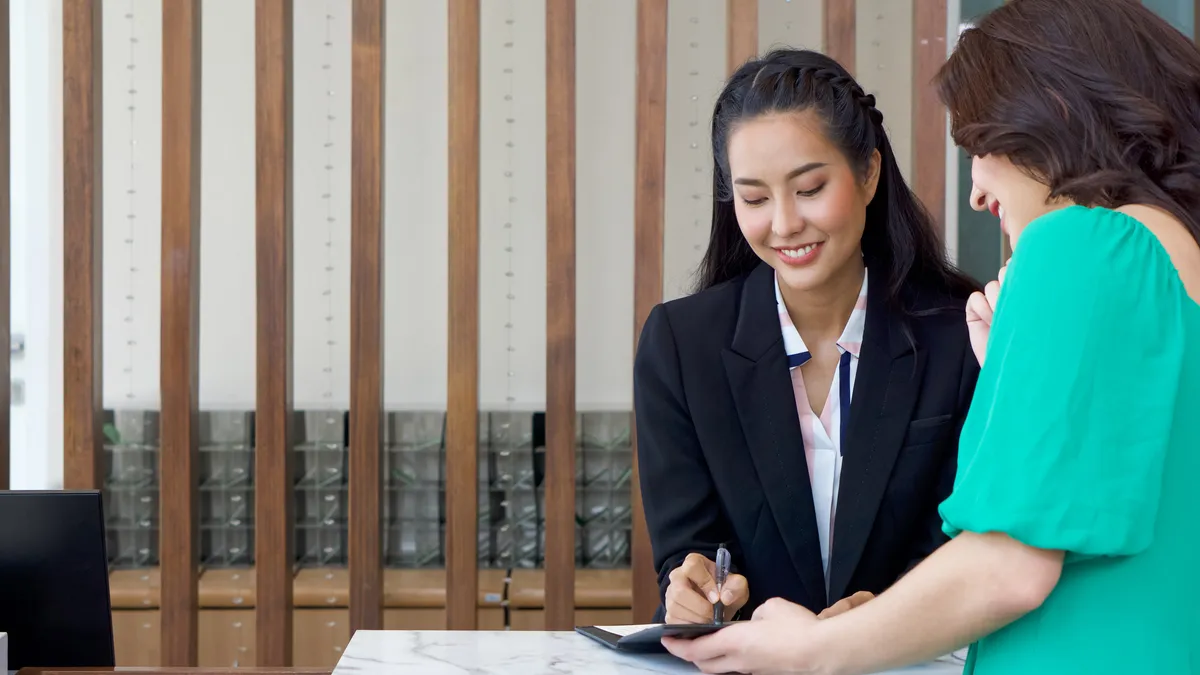 A manager hands a customer a bill.