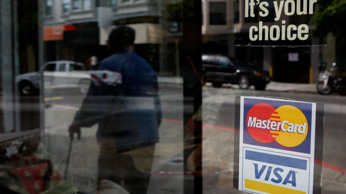 Mastercard and Visa credit card logos on the outside of a glass window