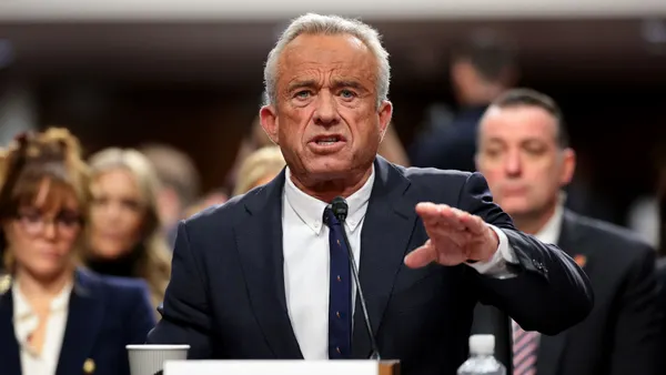 Robert F. Kennedy Jr. speaks while sitting at a desk in a U.S. Senate building.