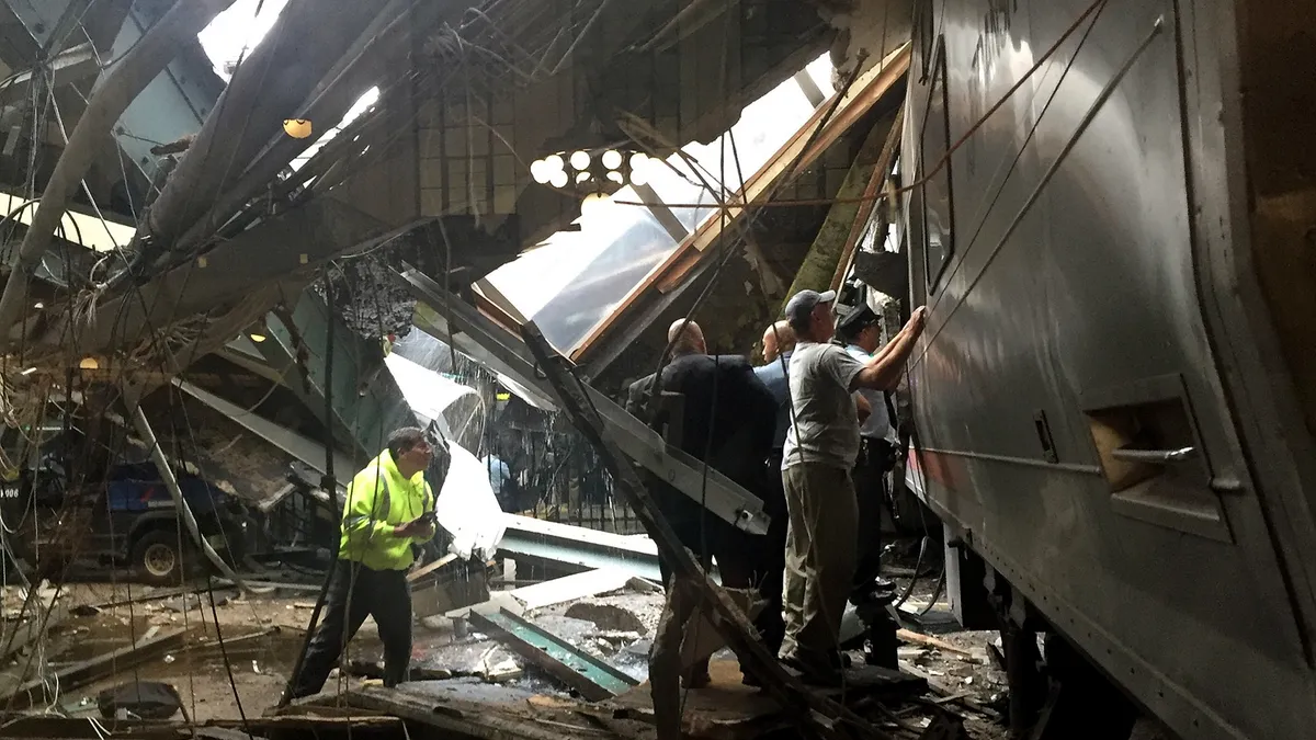 Rail workers survey a passenger train among the wreckage of the Hoboken, New Jersey terminal where the train crashed into the structure.