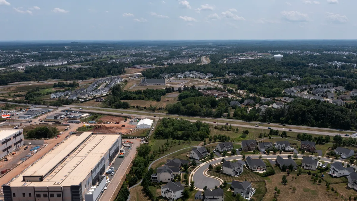 In an aerial view, an Amazon Web Services data center is shown situated near single-family homes on July 17, 2024 in Stone Ridge, Virginia.