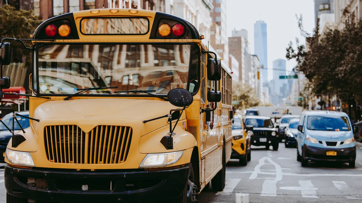 A yellow school bus drives through Manhattan in New York City.