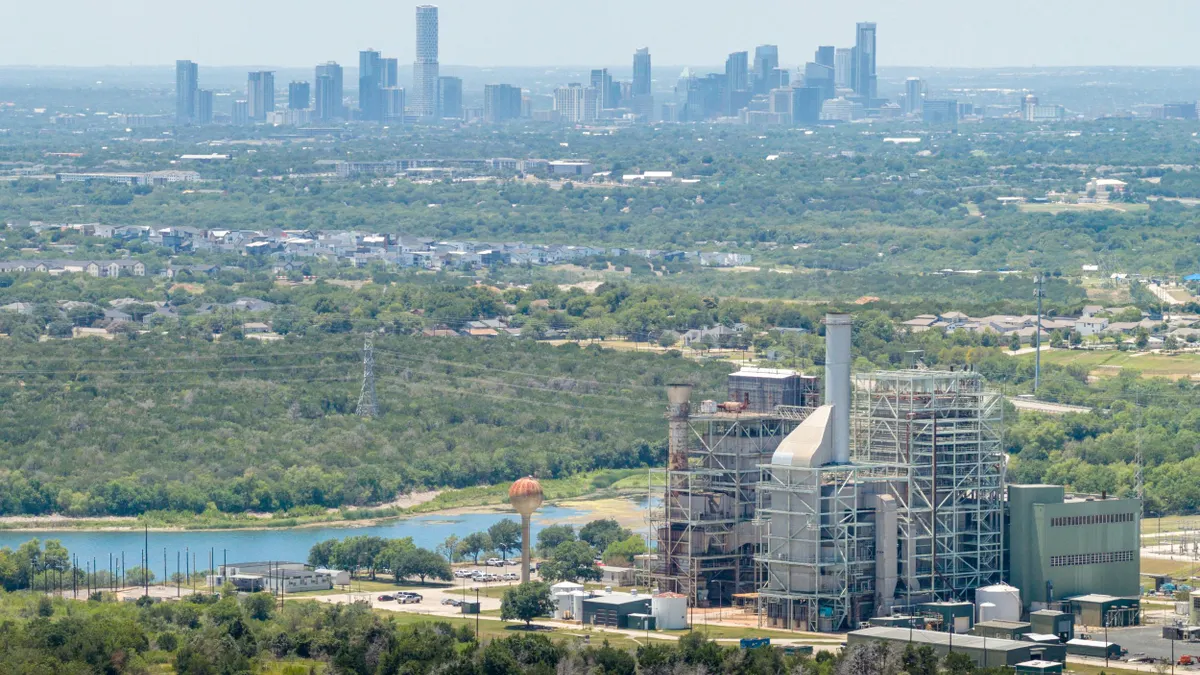 A power plant seen from above with a city in the background
