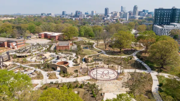Aerial view of park with city skyline in the background.