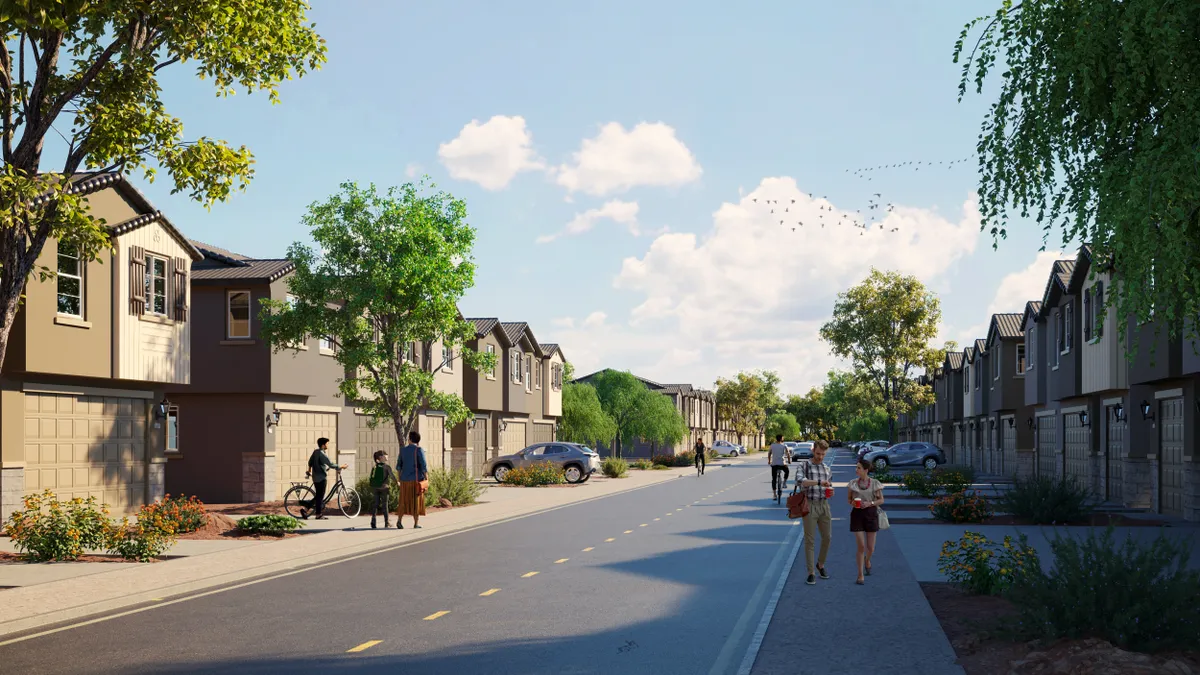 People on a street with brown and tan homes on either side.