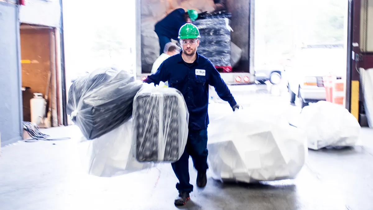 Agilyx employee carrying polystyrene for processing