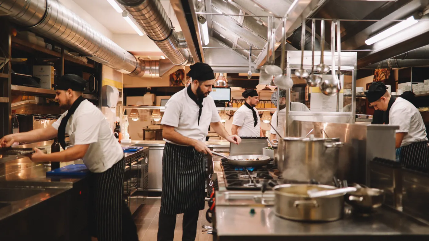 Restaurant kitchen crew preparing food.