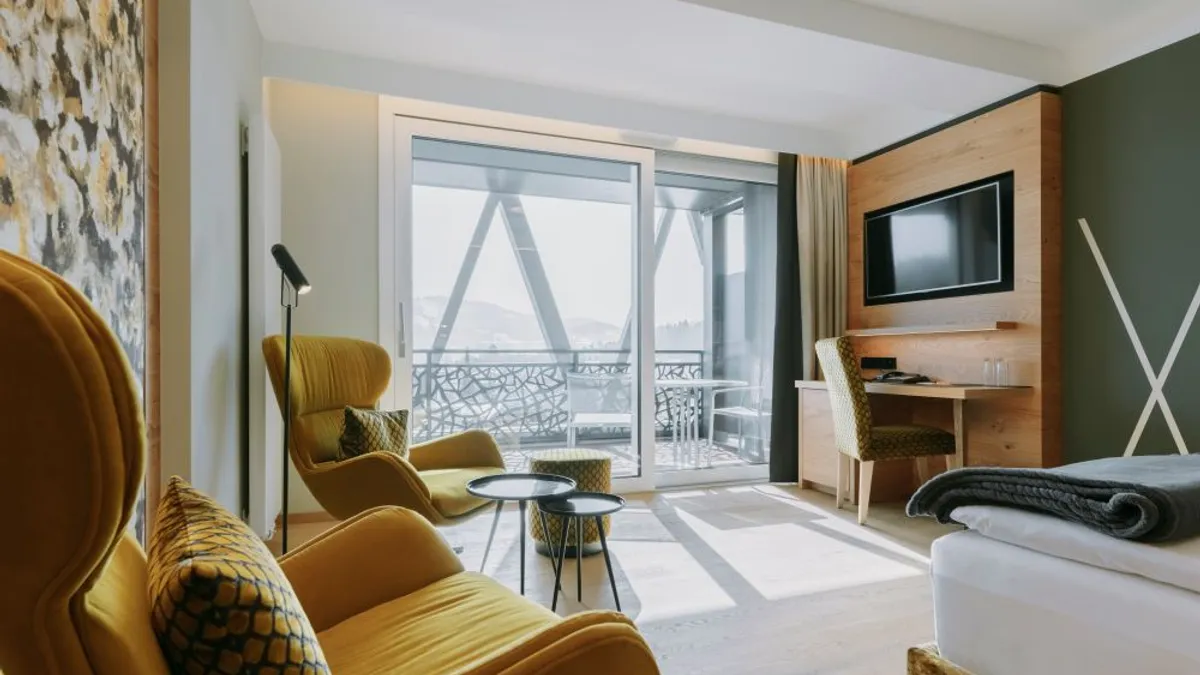 The interior of a hotel room with a desk and bed.