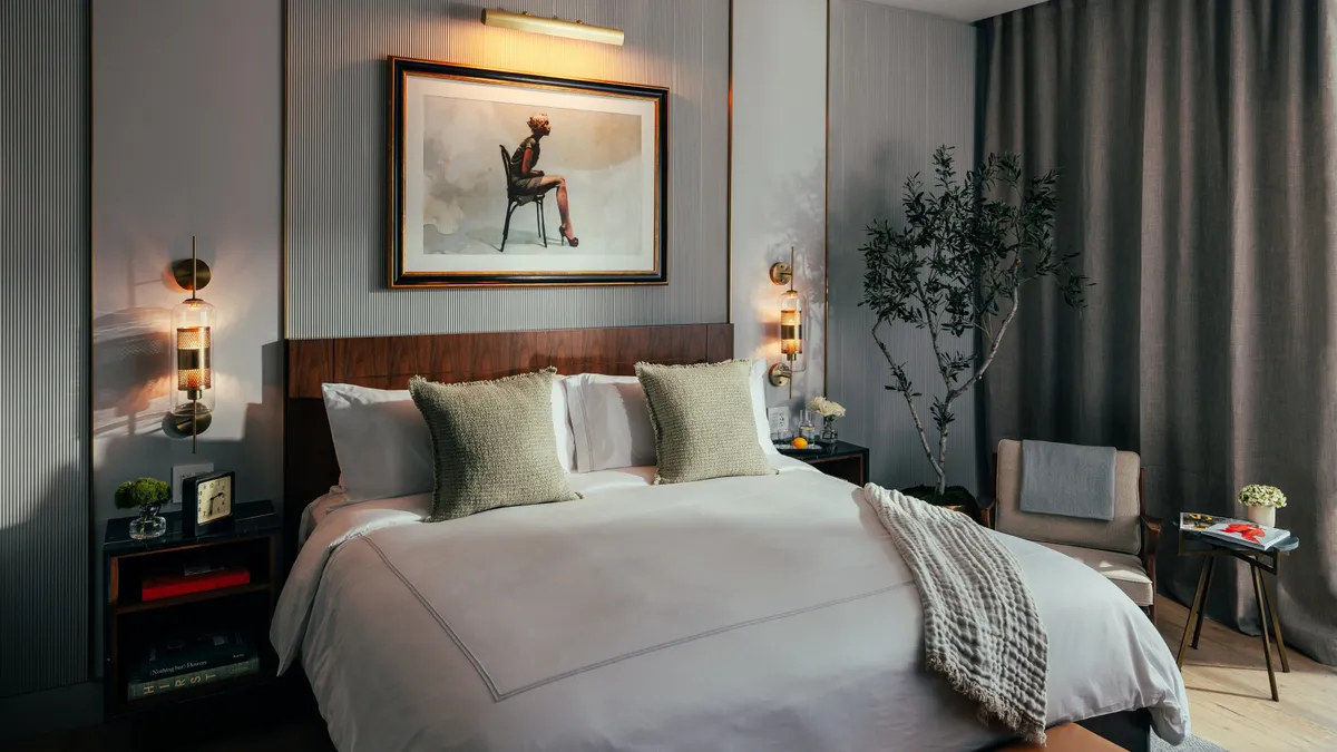 A bed with a white bedspread and dark wood headboard.