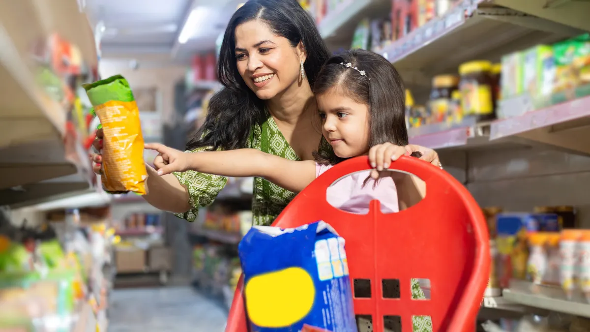 Mother holding product and girl pointing at product.