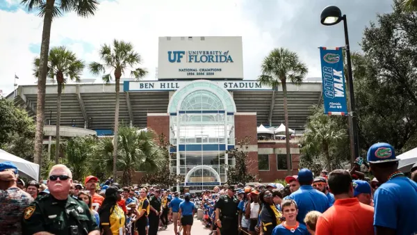 A large crowd gathers outside of a football stadium.