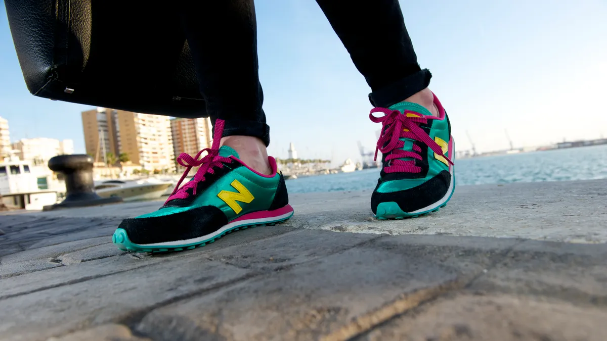 A close up of a person's New Balance sneakers in bright colors.