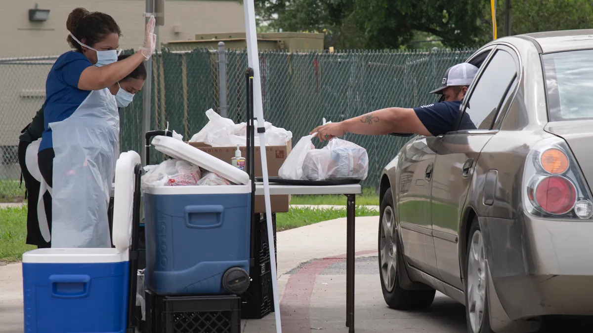 Family picks up school meals from COVID-19 distribution spot.