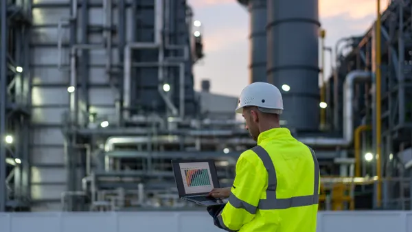 Dedicated successful engineer working in the oil and gas industry until late hours with his laptop.