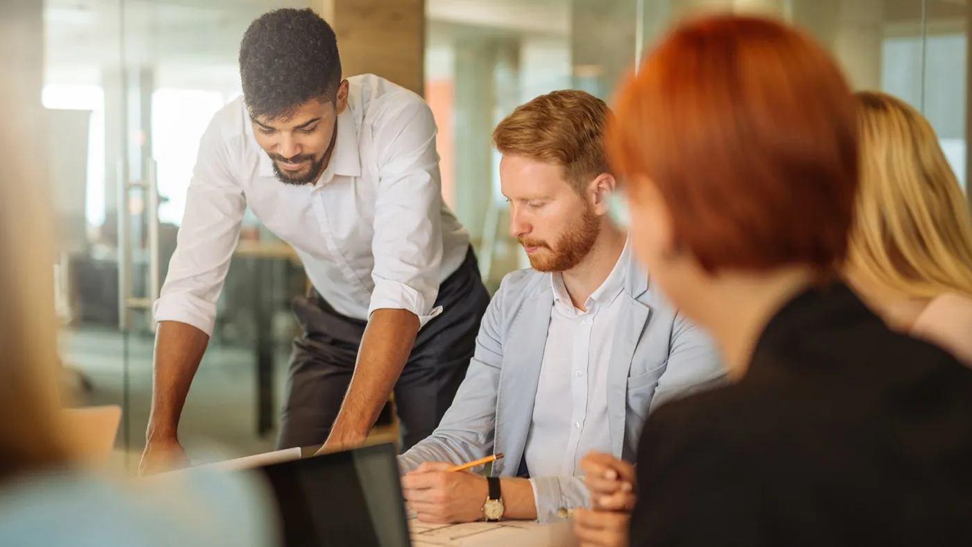 A group of office workers working together at a table.