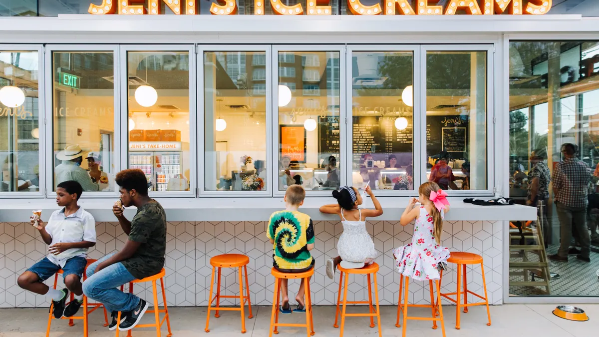 Children and consumers eat ice cream outside a Jeni's Splendid Ice Creams location.