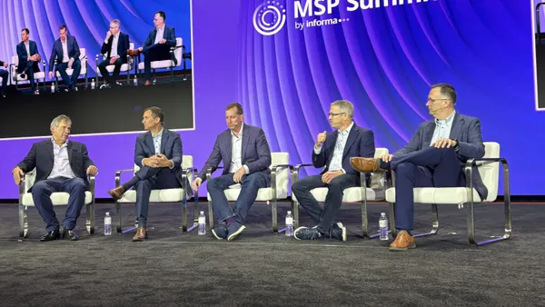 five men sitting on chairs on a keynote stage