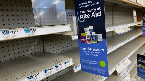 Empty shelves inside a Rite Aid store in New York City on Aug. 28, 2023. A sign on the shelves reads: "Discover big savings on brands exclusively at Rite Aid. Earn 5X points on a $15 purchase July 30-Aug. 26. Look or the green dot on participating products."
