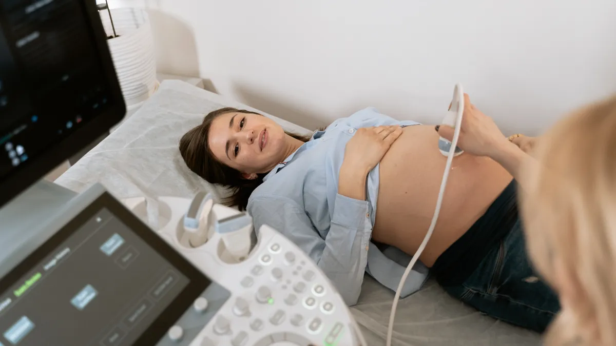 A young pregnant person gets an ultrasound