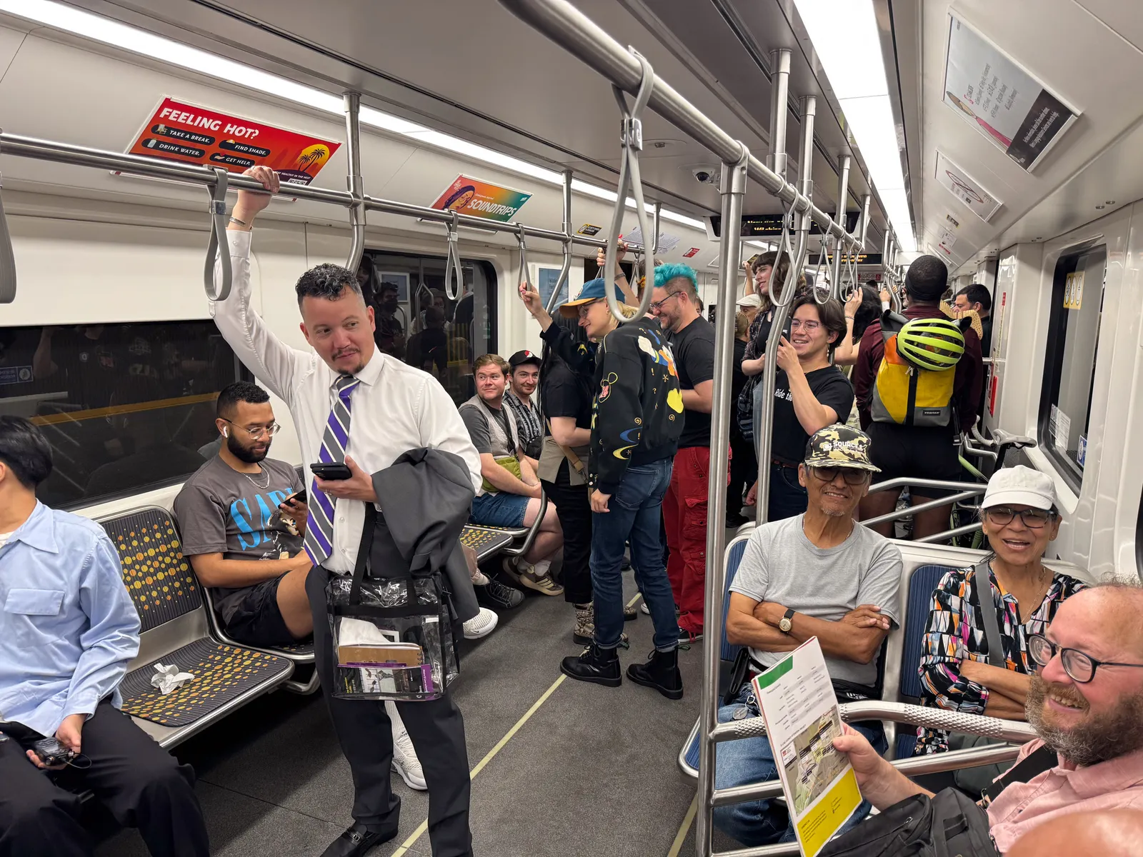 People standing and seated inside a subway car.