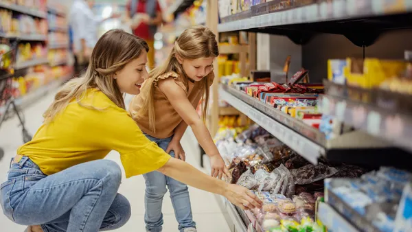 Mother and little girl daughter shopping in the supermarket.