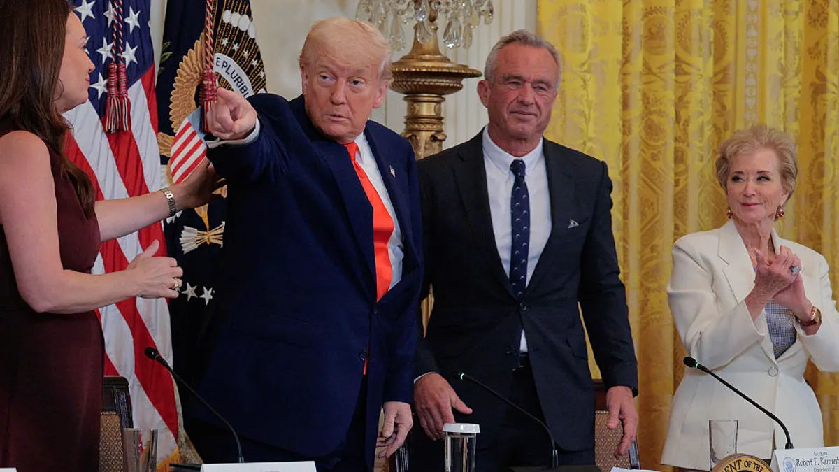 President Donald Trump stands pointing next to Health and Human Services Secretary Robert F. Kennedy Jr.