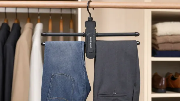 Two pairs of pants hang on a Moralve branded hanger with a closet in the background.