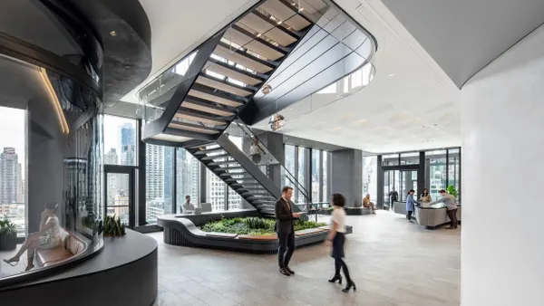 An office building interior with glass and plants and in the lobby.