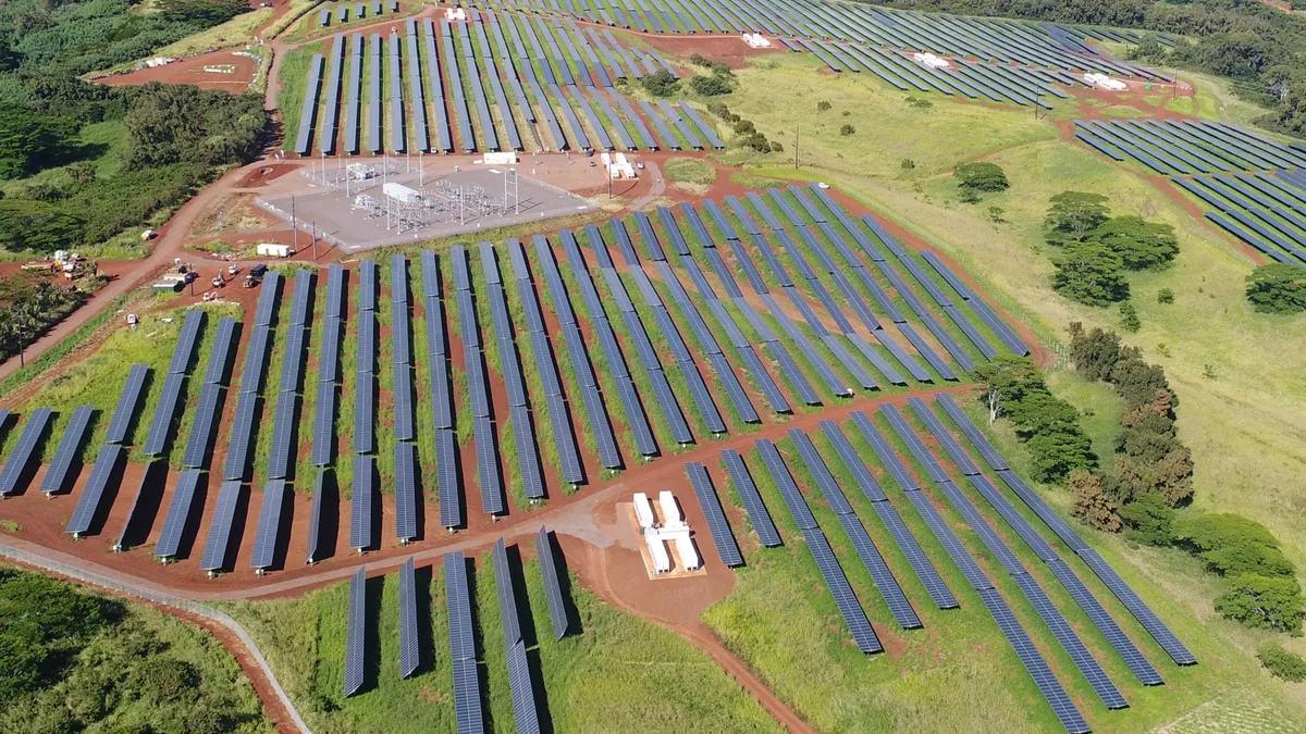 Solar panels spread across a green field.