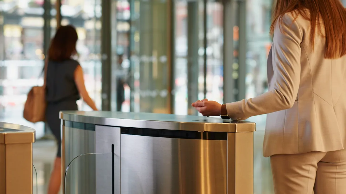 An employee uses an Apple Watch to access an office building.