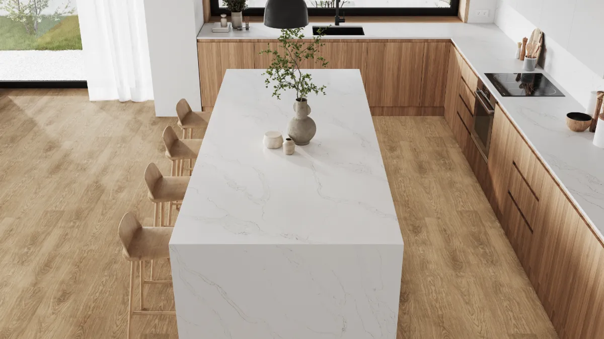 A kitchen with a white waterfall countertop island.