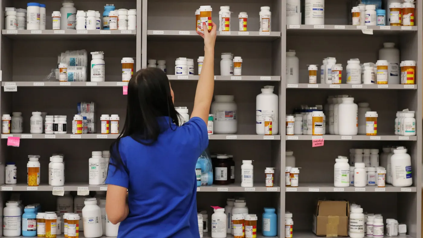 A pharmacy technician grabs a bottle of drugs off a shelve at the central pharmacy of Intermountain Heathcare.