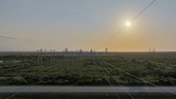 In an aerial view, high voltage power lines run through a sub-station