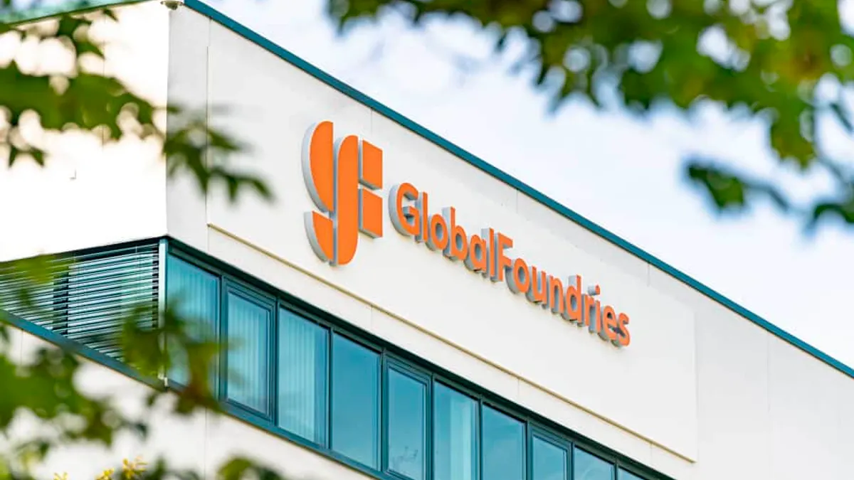 An orange GlobalFoundries logo above windows on a beige building.