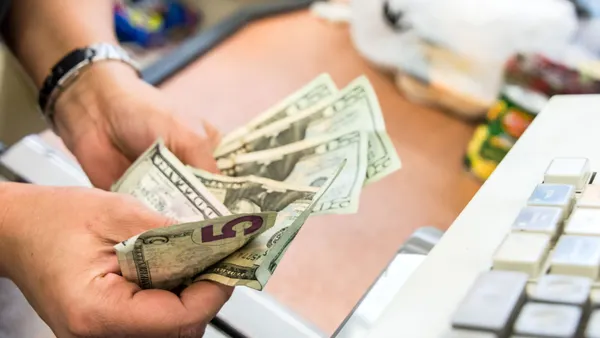 Convenient store cashier counting the cash at the counter