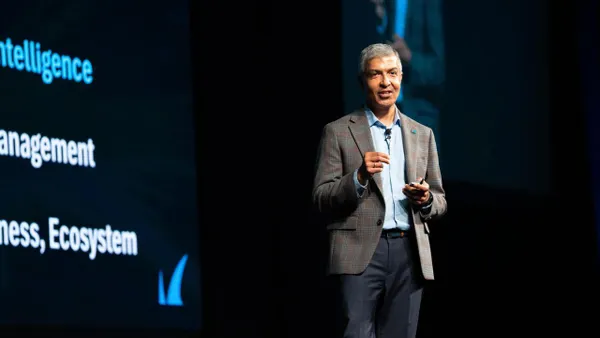 man standing on stage giving a keynote presentation