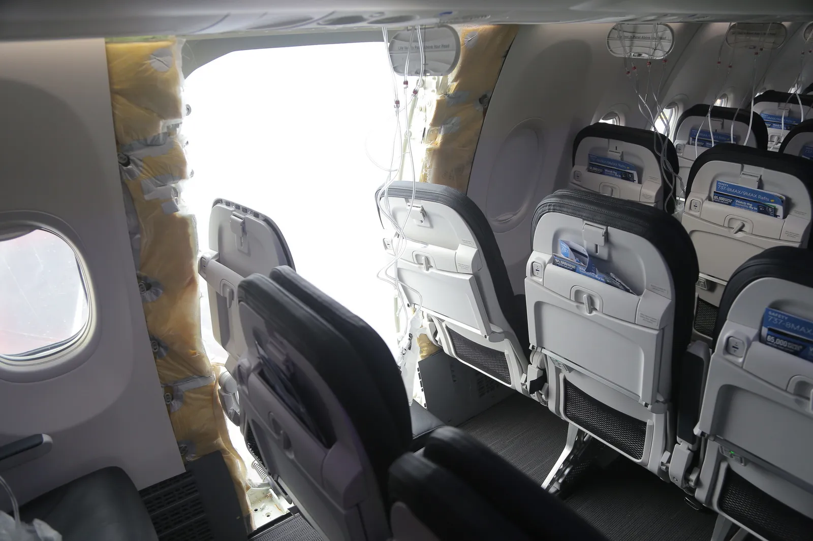 Rows of empty airline seats and an opening inside a Boeing 737-9 Max.