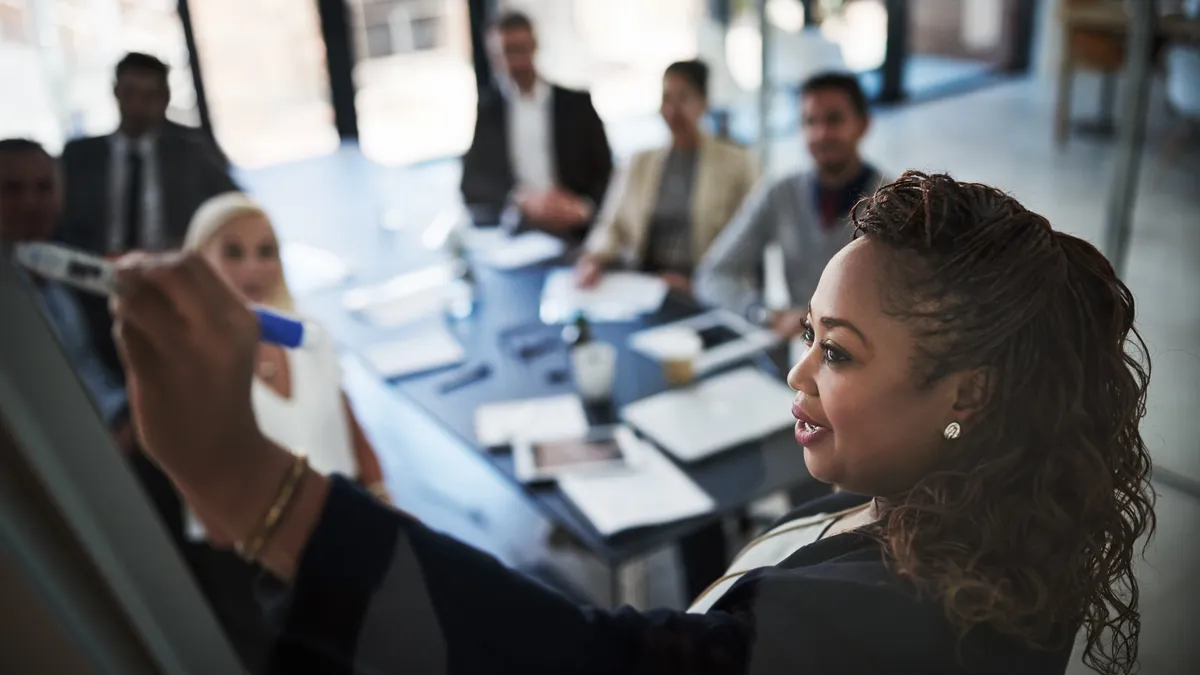 High angle shot of a young businesswoman during a presentation to work colleagues in a boardroom.