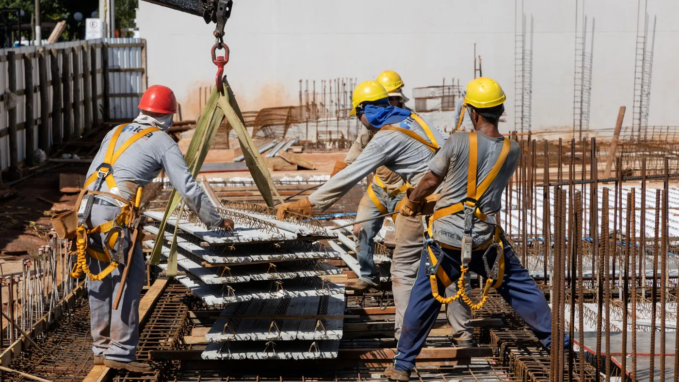 Construction workers move material on a jobsite.